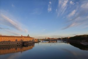Quais de Garonne au coucher du soleil devant les façades roses de Toulouse